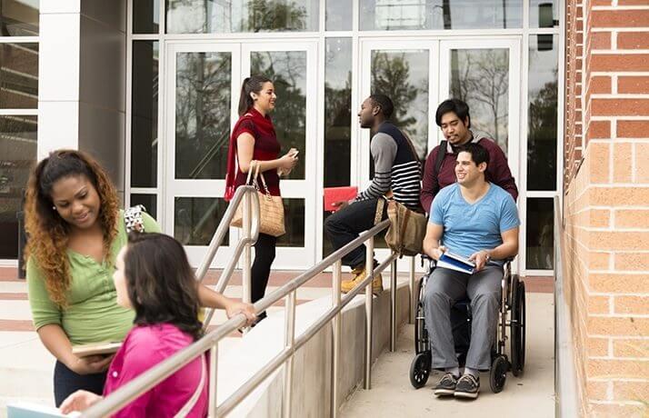 People using a ramp and stairs at a building entrance