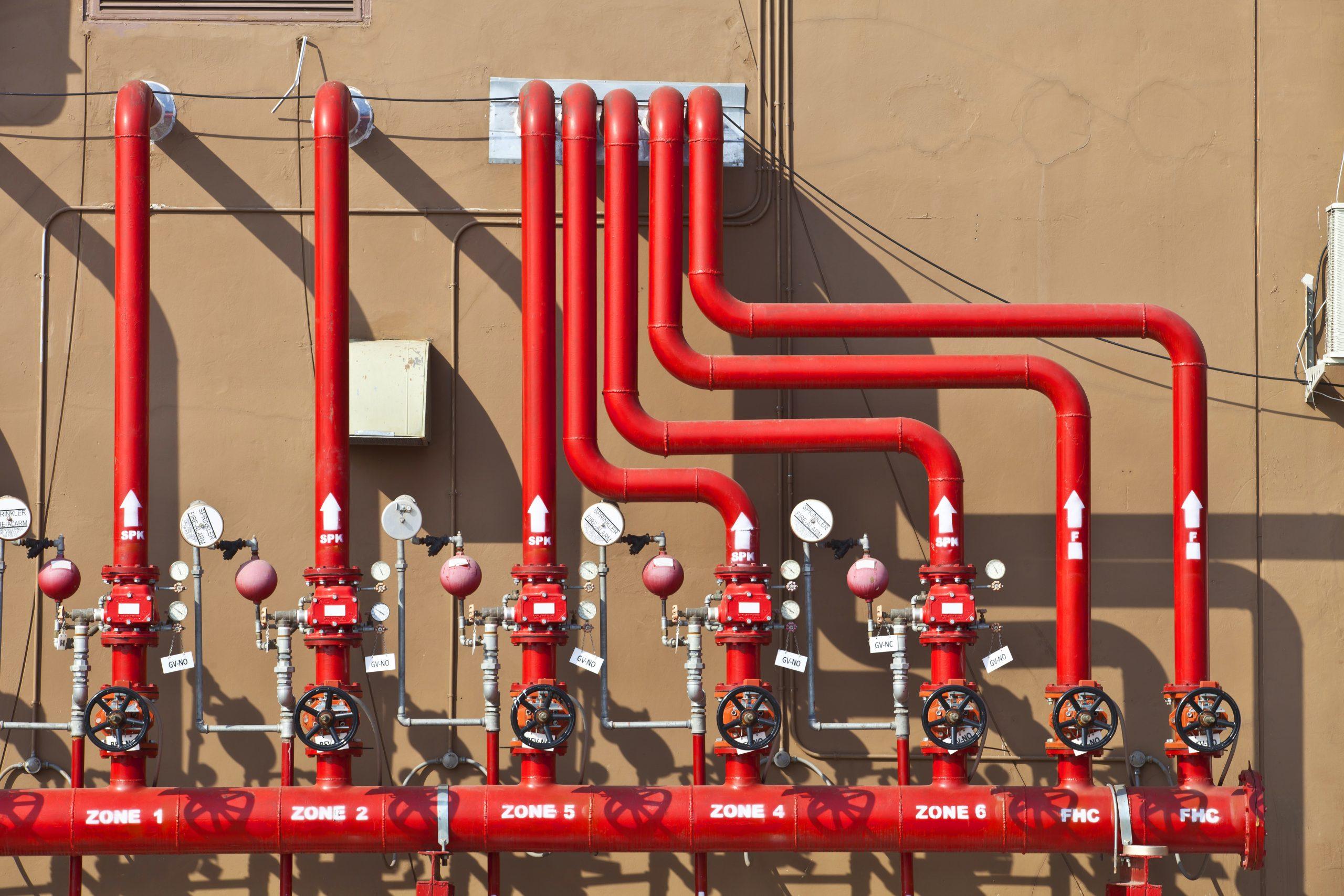 Red fire-protection pipework with valves and pressure gauges