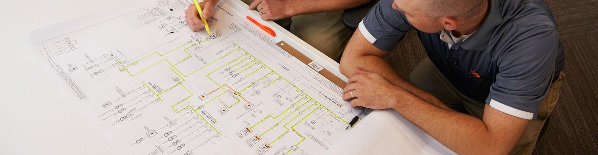 Professional reviewing a large-format building drawing